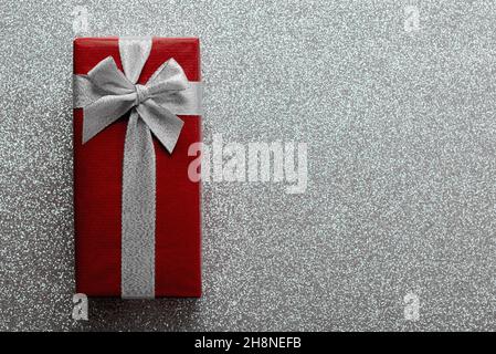 Merry Christmas. Top view of christmas gift box with copy space over bright silver glitter background. Christmas concept background Stock Photo