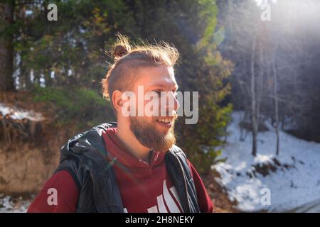 Outdoor portrait of blond bearded smiling hipster man in nature. Stock Photo