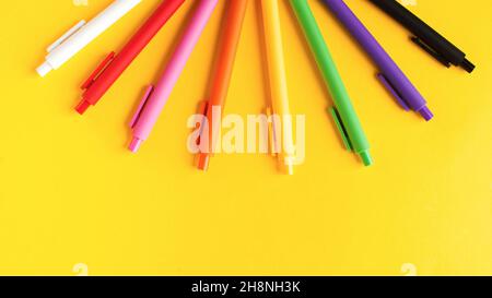 Multi colored pens on a yellow background. Banner. Stationery. Copy space. Stock Photo