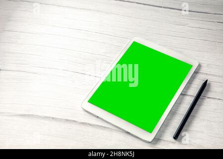 Digital tablet computer with pen and isolated green screen white wooden desk top view, copy space for film,movie, moving image Stock Photo