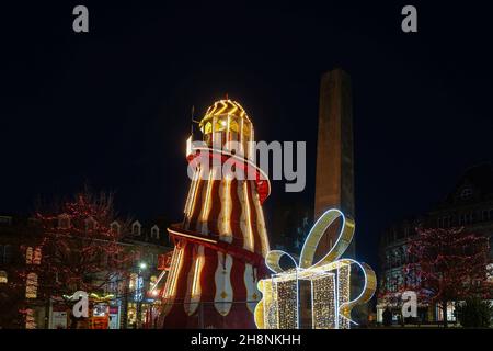 Harrogate's illuminated Helter Skelter and town centre Christmas lights, with the Cenotaph in the distance., North Yorkshire, England, UK. Stock Photo