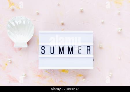 Word SUMMER on pink with seashell decoration and white pearls background. Sea vacation, holiday concept, flat lay, top view, copy space Stock Photo