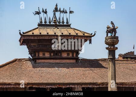 A Hindu guardian lion on a pedestal faces the Bhimsen Temple. Dattatreya Square, Bhaktapur, Nepal. Stock Photo