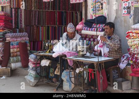 Two tailors sewing on foot-treadle sewing machines in an outdoor shop in Kathmandu, Nepal. Stock Photo