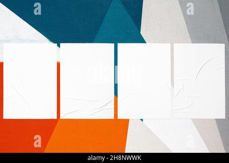 abstract colorful urban wall with four glued posters Stock Photo