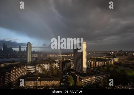 London, UK. 1st December, 2021. UK Weather: A massive rainbow breaks over east London as a brief afternoon rainstorm clears. Credit: Guy Corbishley/Alamy Live News Stock Photo