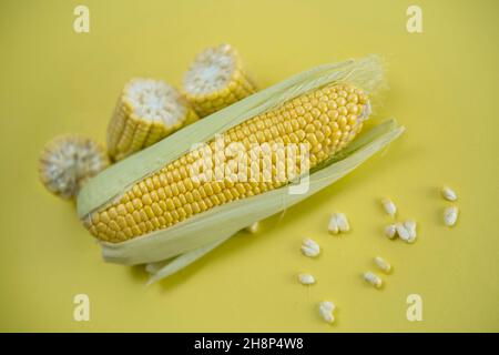 Fresh sweet corn on cobs on yellow background, closeup, top view Stock Photo