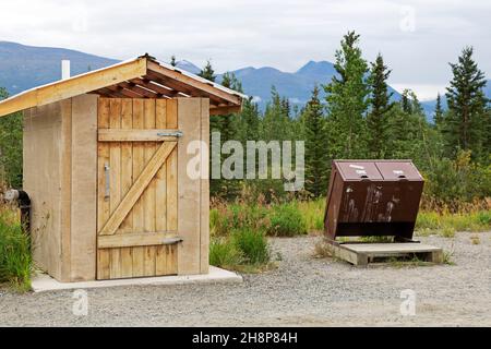Toilet and bins at a highway lay-by in the Yukon, Canada. The bins are designed to be bear safe. Stock Photo