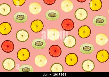 Pattern made of backlit different fruits slices on red background Stock Photo