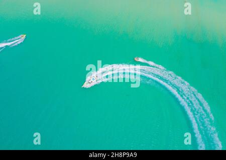 Aerial drone photo of extreme powerboat donut water-sports cruising in high speed in tropical turquoise bay. Thailand, Phuket, Kata beach Stock Photo