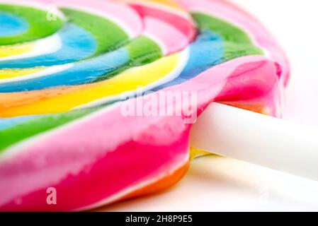 A macro photo of a sweet colorful lollipop in the shape of a spiral, isolated on a white background. Stock Photo
