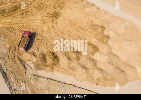 Industrial truck loader excavator moving earth and unloading. Aerial view Stock Photo