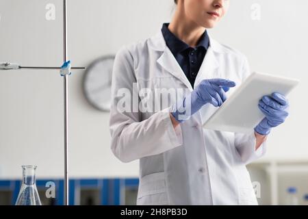 Cropped view of scientist in latex gloves using digital tablet in laboratory Stock Photo