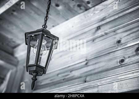 Old lantern against the background of a wooden ceiling. Stock Photo