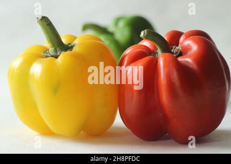 Red yellow and green bell peppers. Bell pepper or Capsicum annuum, also called sweet pepper or capsicum. Bell peppers are used in salads and in cooked Stock Photo
