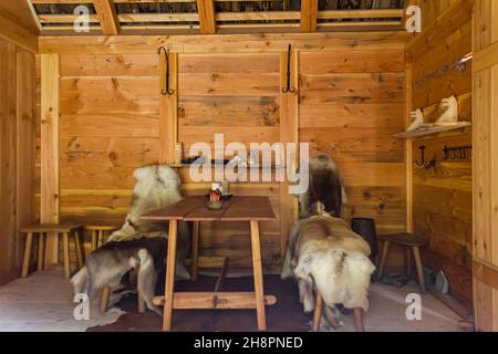 Gudvangen, Norway - Circa September 2021: Interior of a Viking house with fur quilts on chairs Stock Photo
