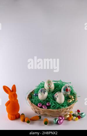 Orange bunny with a filled Easter basket and sweet eggs Stock Photo