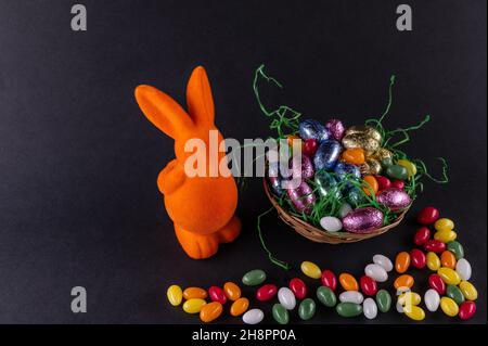 Orange bunny with a filled Easter basket and sweet eggs Stock Photo