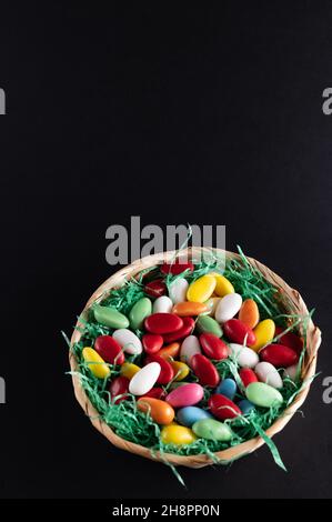 a filled Easter basket with sweet eggs on a dark background Stock Photo