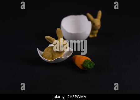 two decorative Easter bunnies with eggshells and a carrot Stock Photo