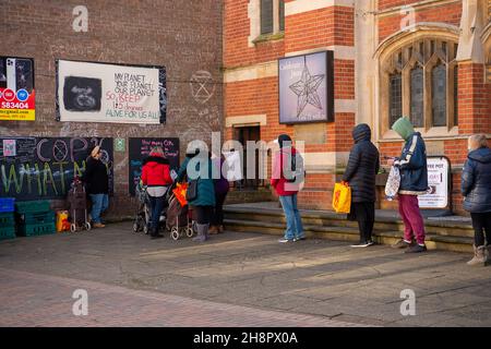 Chesham, Buckinghamshire, UK. 1st December, 2021. People queue outside the Community Fridge in Chesham to purchase a bag of food at a reduced price. Many people are still struggling financially since the Covid-19 Pandemic started. The Community Fridge is a not for profit charity project that aims to redistribute surplus food to the general community that would otherwise become food waste. Credit: Maureen McLean/Alamy Live News Stock Photo