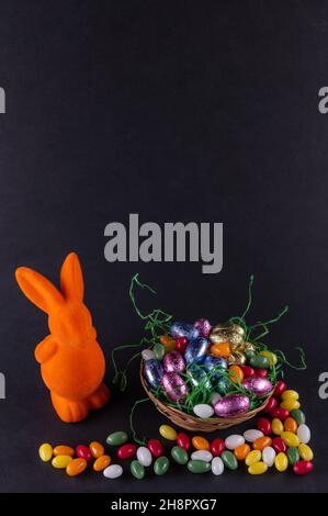Orange bunny with a filled Easter basket and sweet eggs Stock Photo