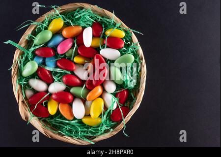 a filled Easter basket with sweet eggs on a dark background Stock Photo