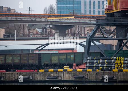 Railroad cars in port for loading unloading. Port cranes unload, load freight railroad cars in industrial port at port terminal Stock Photo