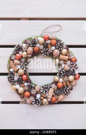 Christmas wreath of pine branches with cones on white wooden background, Christmas balls, copy space Stock Photo