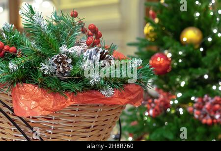 Christmas composition with pine cones, Christmas tree branches and red berries in a wicker basket. Stock Photo