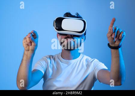 Young man designer or architect in a virtual reality headset working with a project in a virtual space. Future technology concept. Stock Photo