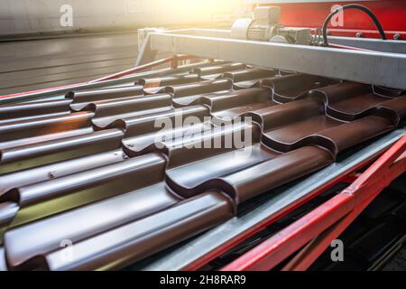 Metal tile for roof in metal forming machine production line close up. Stock Photo