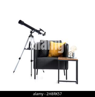 Black armchair with pillow, table and modern telescope on white background Stock Photo