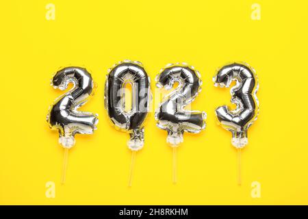 Figure 2023 made of silver balloons on yellow background Stock Photo