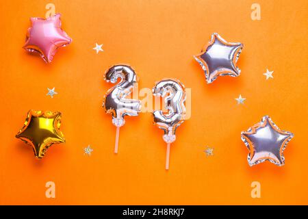 Figure 23 and star shaped balloons on color background Stock Photo