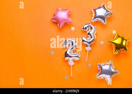 Figure 23 and star shaped balloons on color background Stock Photo