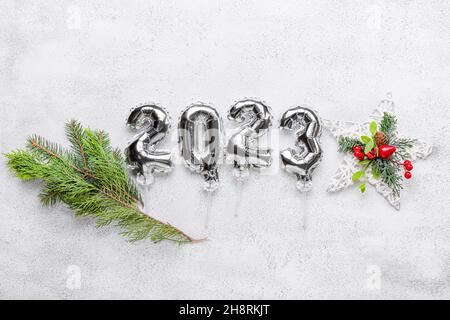 Figure 2023 made of silver balloons and Christmas decor on light background Stock Photo