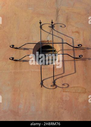 Window of old adobe builing with ornamental iron bars. Stock Photo