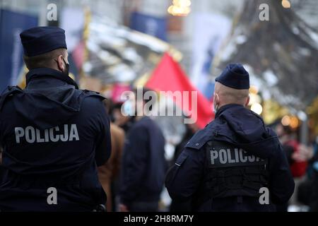 Police officers looking at the protesters during the demonstration. Earlier this year Poland imposed a state of emergency on the border with Belarus as for some time foreigners, including citizens of Iraq, Afghanistan, Syria and Yemen as well as African countries, have been reaching Poland at various points on its border with Belarus. People are refused to seek refuge and cross the border which led to deaths, including children. The situation on the Polish-Belarusian boarder has polarized Poles as some people oppose the treatment of the refugees that gathered on the grounds between the two cou Stock Photo