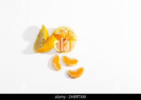 Half peeled tangerine and three tangerine wedges on a white background. Isolate. Life style. Clos ap. Horizontal photo. High quality photo Stock Photo