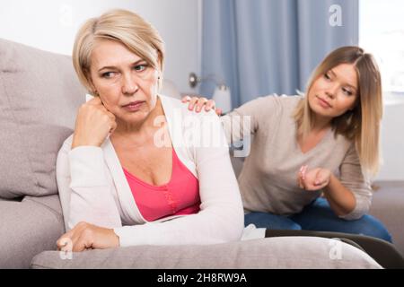 daughter comforts a sad mother Stock Photo