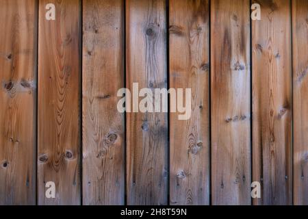 fading weathered deck boards, vertical with knots, turning grey, orange, brown Stock Photo