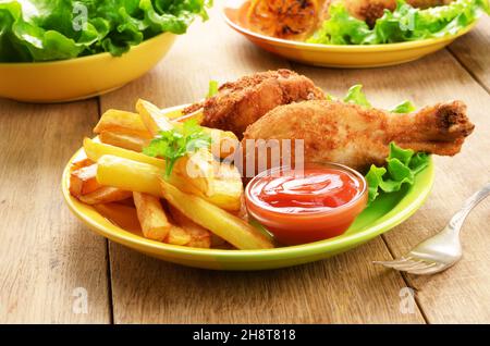 Fried chicken legs with french fries on the table Stock Photo