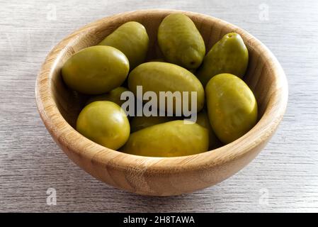 Bowl with Italian green olives from Cerignola. Bella di Cerignola Italian olives on wooden table Stock Photo