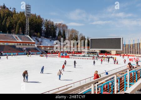 Almaty, Kazakhstan - March 02, 2021: People go ice skating on the famous high-mountain skating rink Medeu Stock Photo