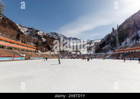 Almaty, Kazakhstan - March 02, 2021: People spend their day off at the famous Medeo high-altitude skating rink Stock Photo