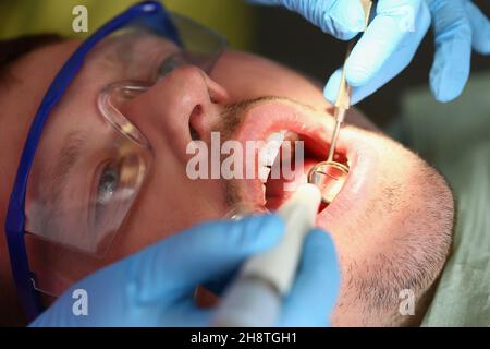 A man treats teeth, a patient's calm face close-up Stock Photo