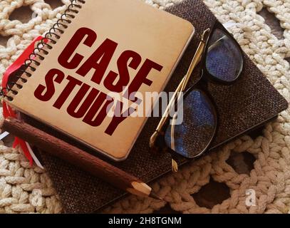Case study memo written on a notebook with pen, glasses on crochet cloth. Successful business cases educational concept Stock Photo