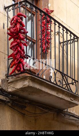 Strung red peppers drying on balcony in village of Briones, La Rioja Alta, Spain Stock Photo