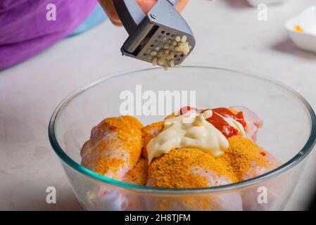 chicken drumsticks in a cup add garlic Stock Photo